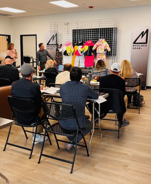 A group watching a Boulder Gear display presentation